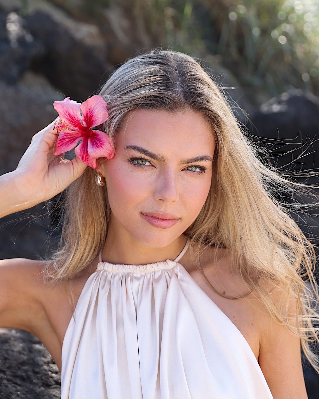 Sun-kissed skin with a hibiscus in her hair